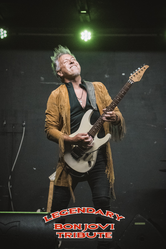 Legendary guitarist mid-solo in a fringed suede jacket